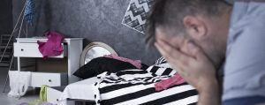 sad man looking at messy home after a break-in